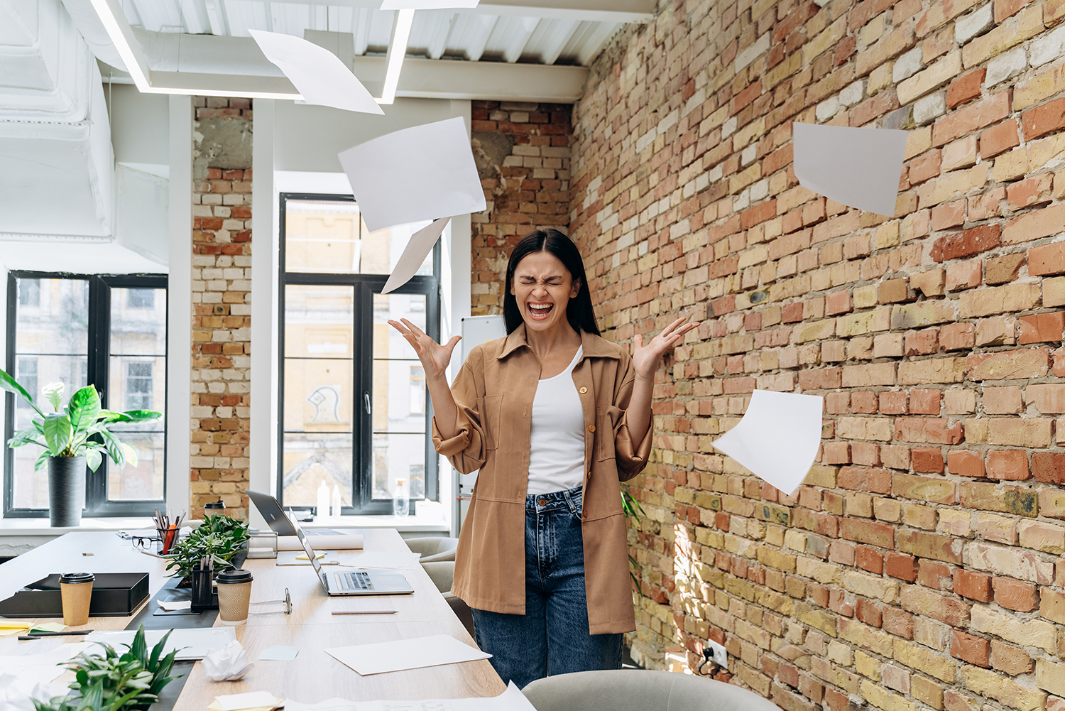 Small business owner frustrated throwing up papers