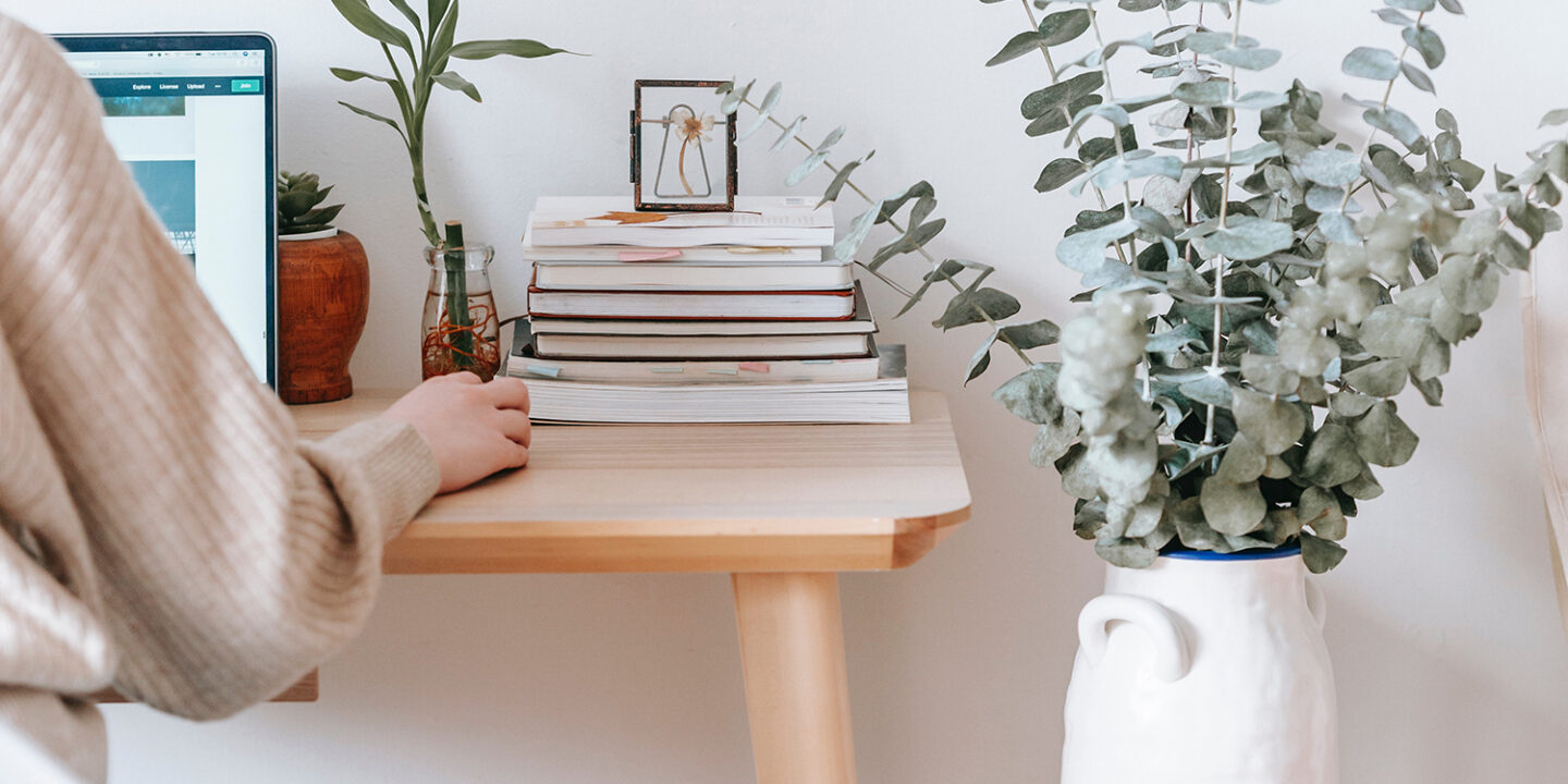 lady on CRM with stack of books on her desk