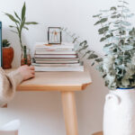 lady on CRM with stack of books on her desk
