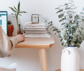 lady on CRM with stack of books on her desk
