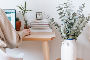 lady on CRM with stack of books on her desk